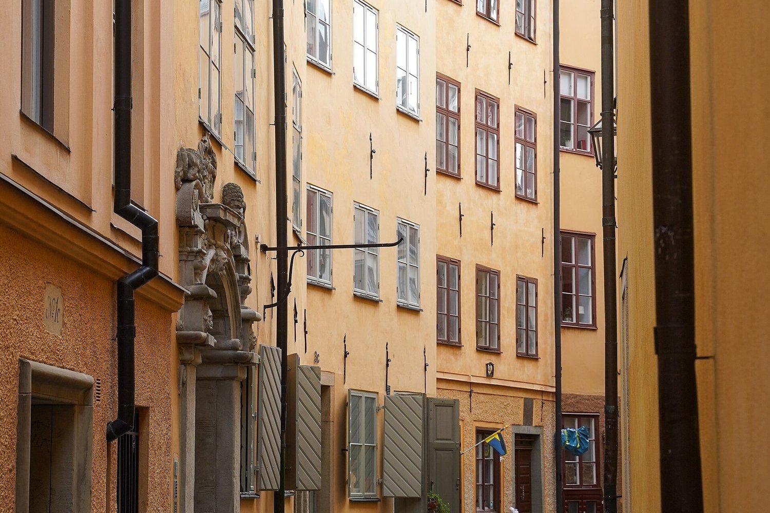 A narrow cobbled alley between ochre buildings in Gamla Stan, Stockholm